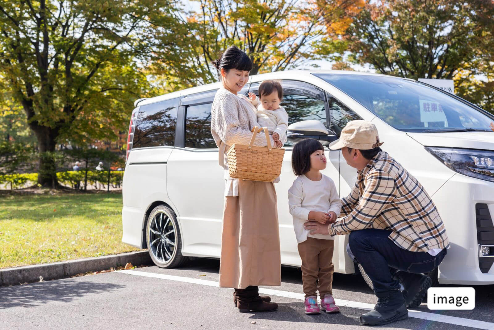駐車場で車を利用する家族